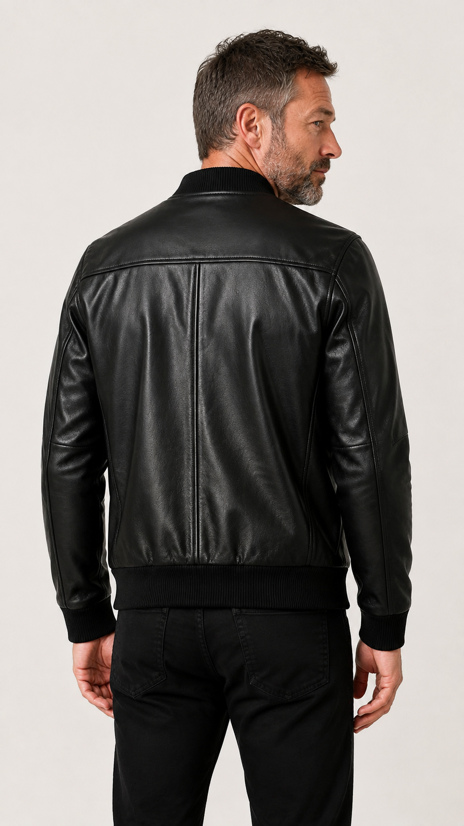 Back view of a man wearing the black leather bomber jacket — British model